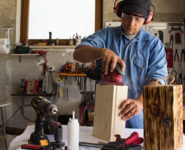 Un homme en train de travailler du bois dans son atelier de bricolage