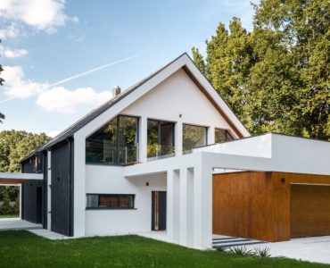 Vue extérieure d'une maison moderne à architecture en A, avec un garage décoré de bois