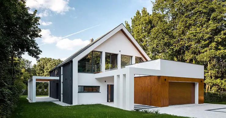 Vue extérieure d'une maison moderne à architecture en A, avec un garage décoré de bois