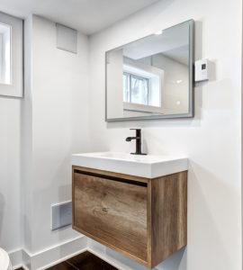 Une toilette avec une porte en bois et des fenêtres vitrées