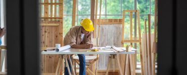 Un homme en casque de chantier travaillant sur la table d’un atelier