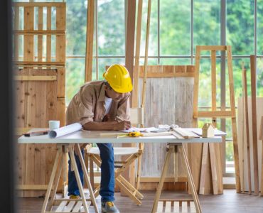 Un homme en casque de chantier travaillant sur la table d’un atelier