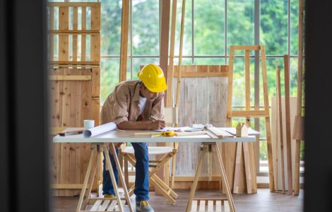 Un homme en casque de chantier travaillant sur la table d’un atelier