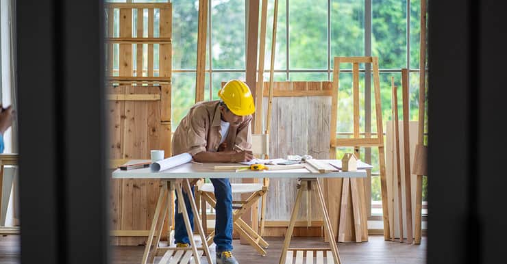 Un homme en casque de chantier travaillant sur la table d’un atelier