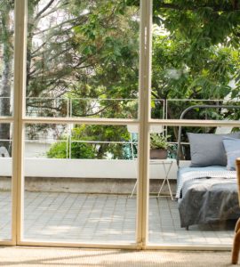 Vue sur un lit à l'extérieur de la maison à travers une baie vitrée