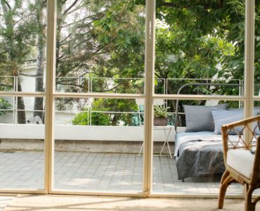 Vue sur un lit à l'extérieur de la maison à travers une baie vitrée