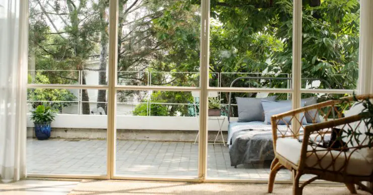 Vue sur un lit à l'extérieur de la maison à travers une baie vitrée