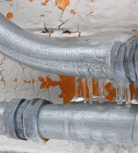 Focus sur une canalisation gelée et un mur qui s’écaille