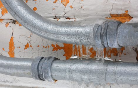 Focus sur une canalisation gelée et un mur qui s’écaille