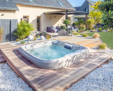 Spa extérieur posé sur le parquet en bois de la terrasse