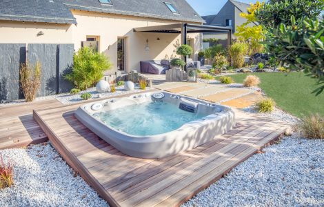 Spa extérieur posé sur le parquet en bois de la terrasse