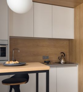 Petite cuisine moderne avec des placards blancs et des suspensions lumineuses blanches