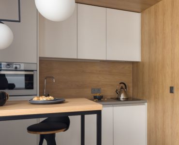 Petite cuisine moderne avec des placards blancs et des suspensions lumineuses blanches