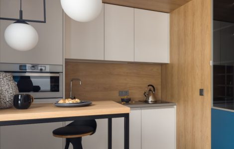 Petite cuisine moderne avec des placards blancs et des suspensions lumineuses blanches