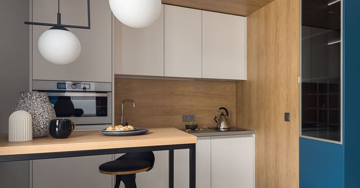 Petite cuisine moderne avec des placards blancs et des suspensions lumineuses blanches