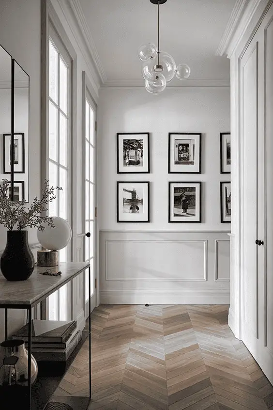Des photos en noir et blanc bien alignées pour ce couloir à la décoration plus épurée