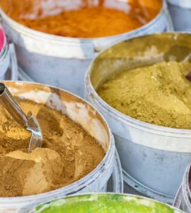 Différentes couleurs de peinture en poudre dans des seaux blancs