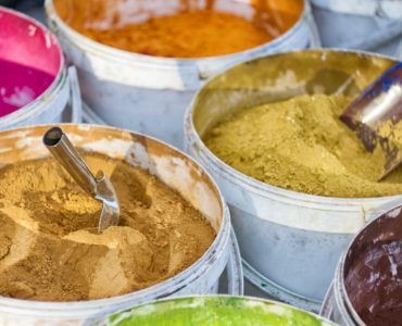 Différentes couleurs de peinture en poudre dans des seaux blancs