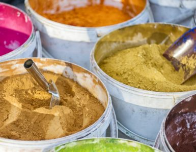 Différentes couleurs de peinture en poudre dans des seaux blancs