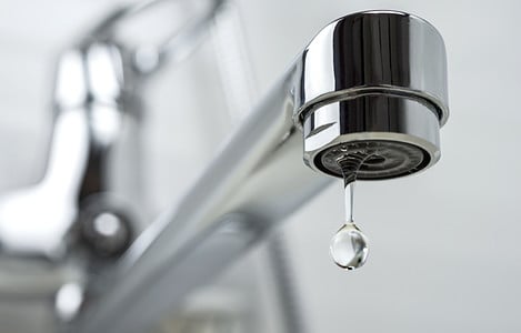 Zoom sur une goutte d’eau qui tombe d’un robinet