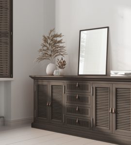 Un miroir rectangulaire posé sur une commode en rotin foncé
