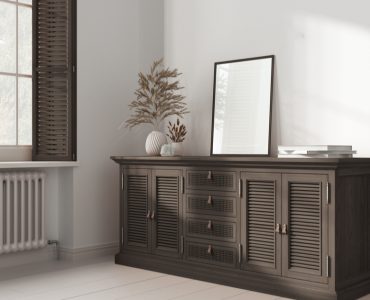 Un miroir rectangulaire posé sur une commode en rotin foncé