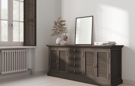 Un miroir rectangulaire posé sur une commode en rotin foncé