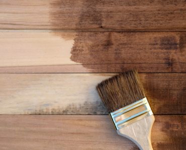Vue de dessus des panneaux en bois à moitié recouverts de peinture avec un pinceau
