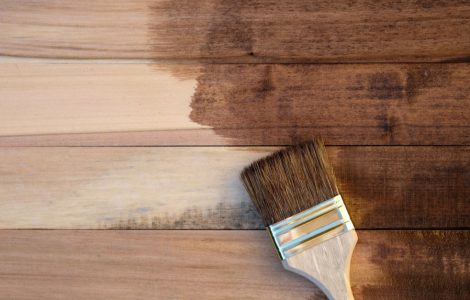 Vue de dessus des panneaux en bois à moitié recouverts de peinture avec un pinceau