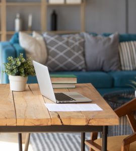 Un ordinateur portable posé sur une table de bureau en bois dans le salon