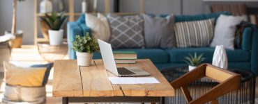 Un ordinateur portable posé sur une table de bureau en bois dans le salon