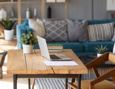 Un ordinateur portable posé sur une table de bureau en bois dans le salon