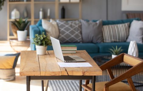 Un ordinateur portable posé sur une table de bureau en bois dans le salon