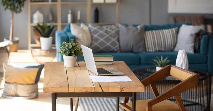 Un ordinateur portable posé sur une table de bureau en bois dans le salon