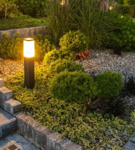 Une borne lumineuse LED éclairant l’escalier et le jardin à la tombée de la nuit