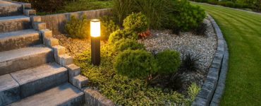 Une borne lumineuse LED éclairant l’escalier et le jardin à la tombée de la nuit