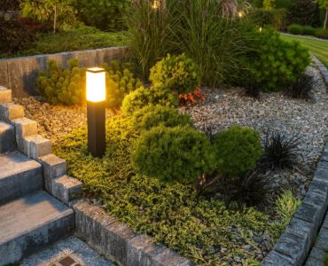 Une borne lumineuse LED éclairant l’escalier et le jardin à la tombée de la nuit