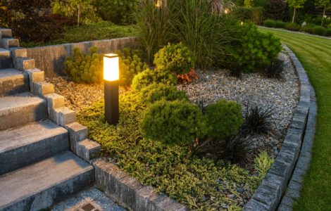 Une borne lumineuse LED éclairant l’escalier et le jardin à la tombée de la nuit