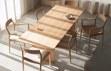 Une table à manger en bois clair et chaises en bois assortis