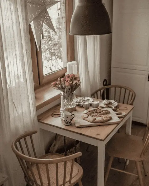 Une petite table carrée sous la fenêtre de la cuisine