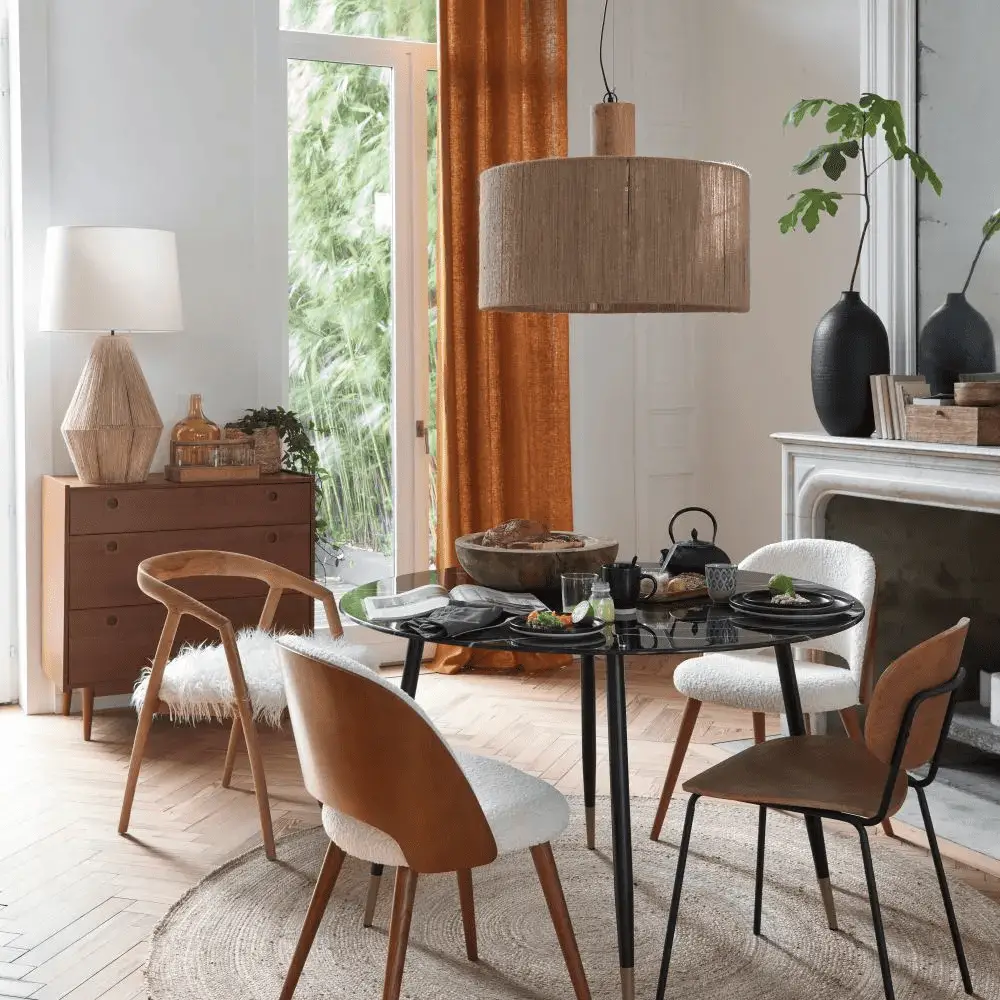 Une table à manger ronde moderne effet marbre noir et pied en laiton pour 5/6 pers