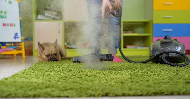 Une femme nettoie le tapis avec un nettoyeur vapeur dans la chambre des enfants