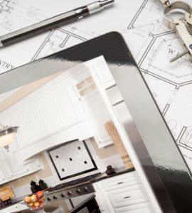 Une tablette, posée sur des plans de maison, montrant une illustration de cuisine