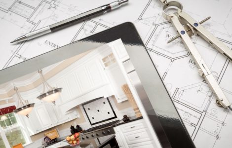 Une tablette, posée sur des plans de maison, montrant une illustration de cuisine