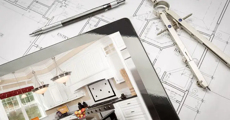 Une tablette, posée sur des plans de maison, montrant une illustration de cuisine