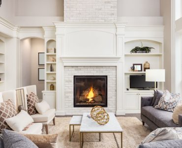Un salon cosy avec une cheminée et une grande baie vitrée