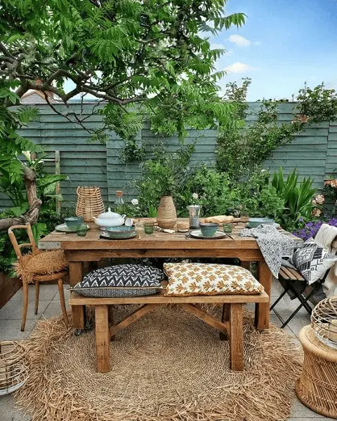 Plusieurs coussins à motifs pour décorer le coin repas d'une petite terrasse