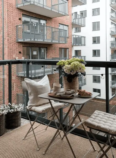 Un grand tapis tissé pour habiller le sol en béton d'un petit balcon