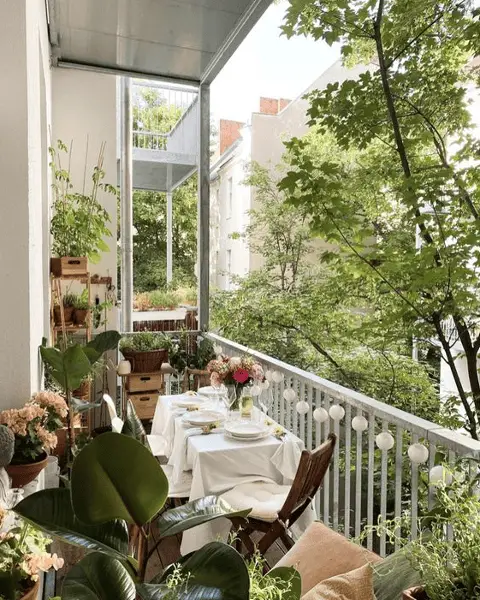 Une petite table vêtue d'une nappe sur un balcon 