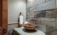 Une petite salle de bains avec un mur imitation pierre
